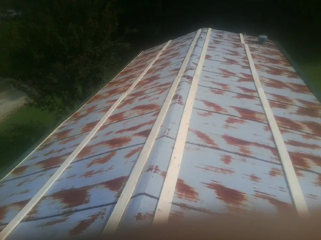 Rusted metal roof panels with new wood purlins before replacement — Storm Damage Roof Repair in Great Barrington by Roofing Brothers
