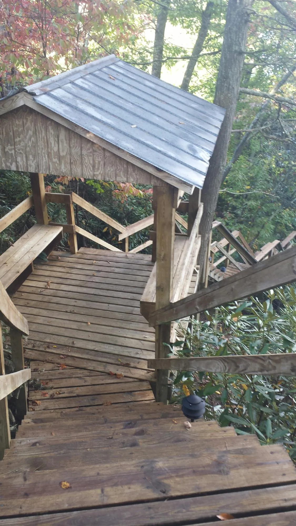 Metal roofed shelter over wooden steps on a wooded walkway — Skylight Repair & Installation work by our crew in Great Barrington